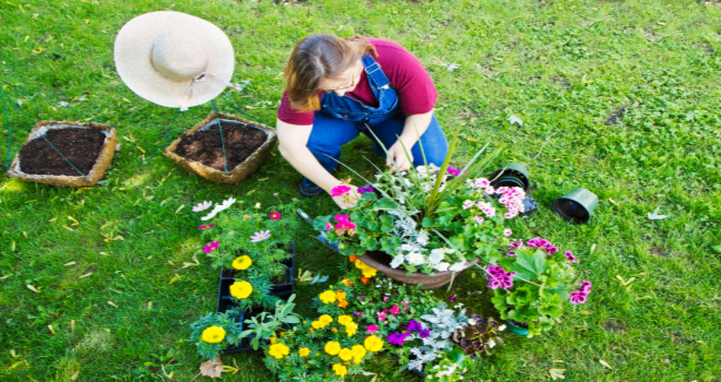 Leidenschaftliche Gärtnerin gestaltet blühende Oase: Eine Frau bepflanzt Pflanzgefäße im Garten"